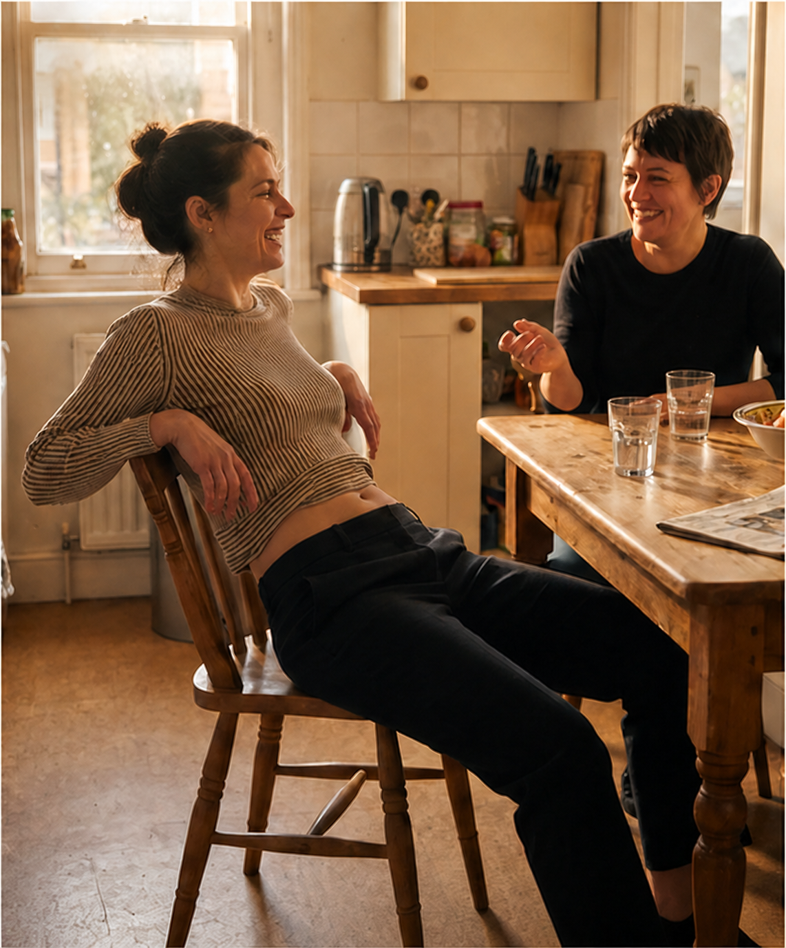 Dos mujeres riendo sentadas a la mesa después de comer
